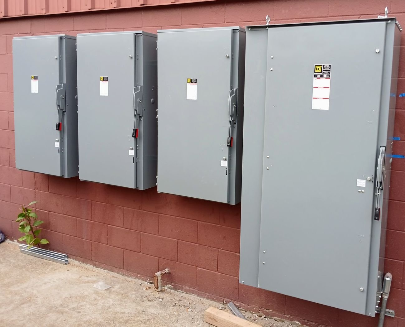 Row of exterior electrical disconnects installed on a brick commercial building