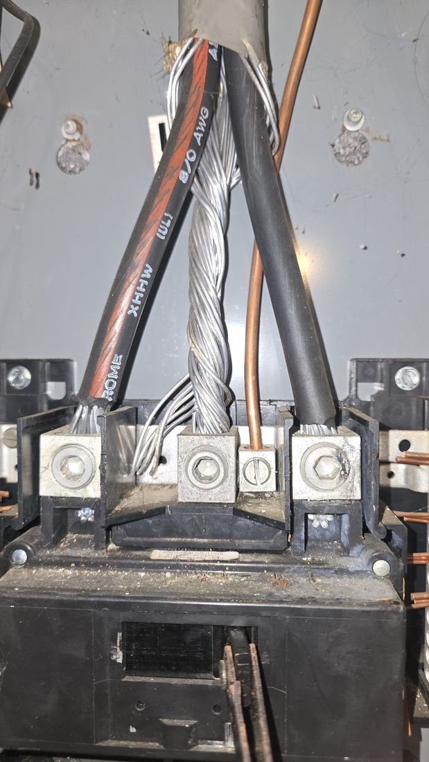 Panel lug burned by an arc during installation, with a neutral conductor only partly seated