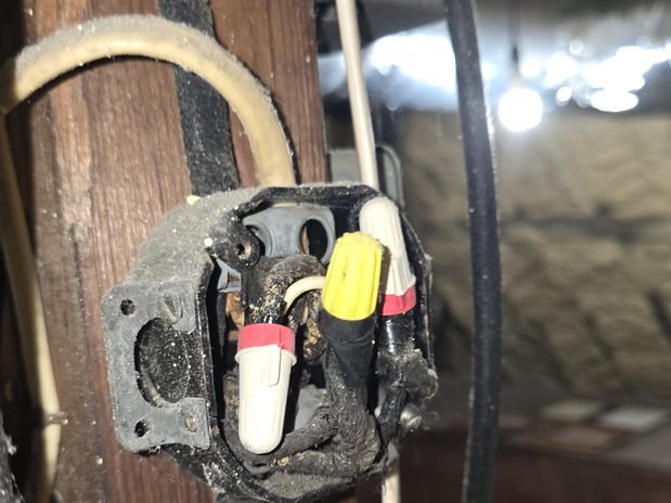 Old junction box and cloth-covered cable on an attic beam