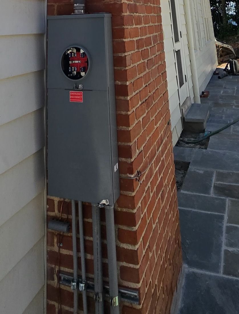 Exterior meter base and service disconnect mounted on a brick home